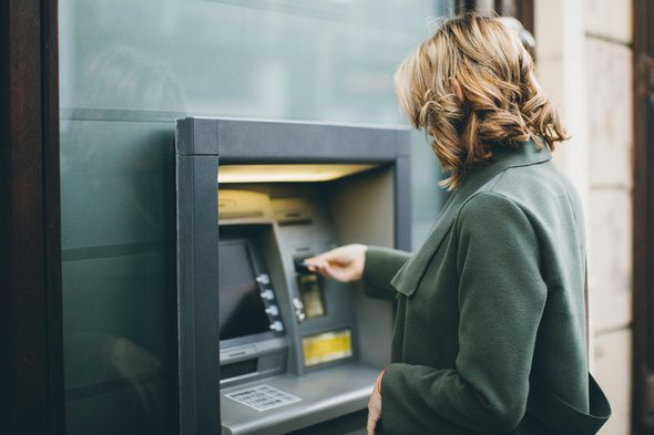A woman withdrawing money from an ATM.