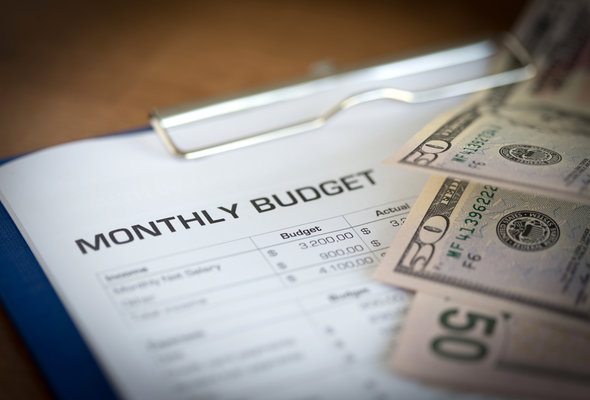 Money and a sheet labeled "monthly budget."