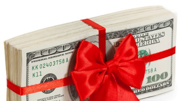 A stack of one-hundred dollar bills wrapped in red ribbon.