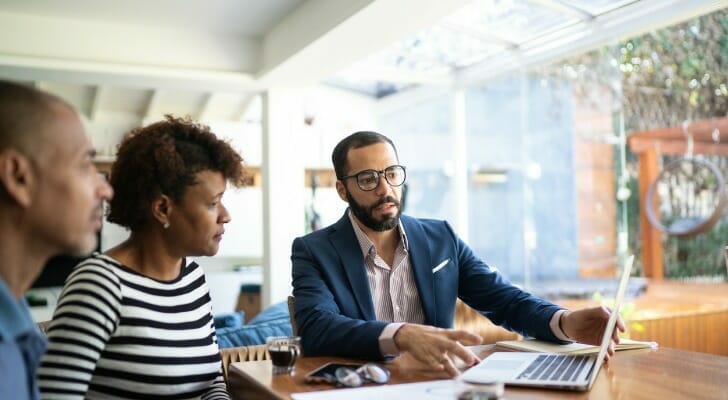 A couple discuss capital gains tax rates with their advisor.