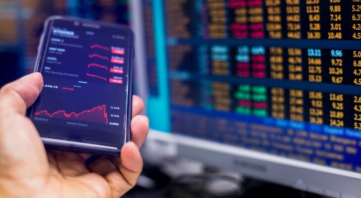 An investor reviewing their investment portfolio, on personal computer and mobile phone.