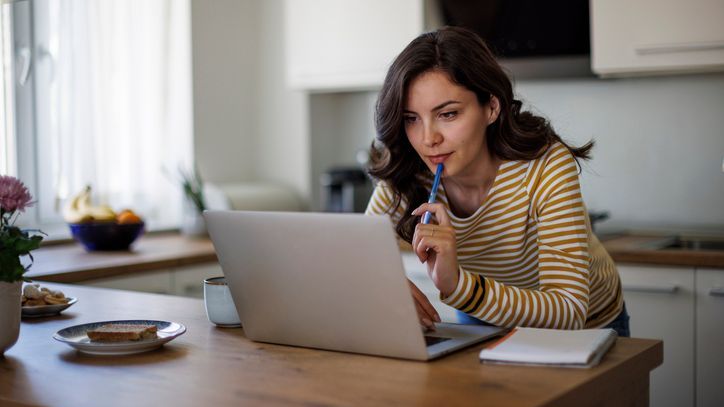 A woman looks at properties online to determine how to invest $200,000 she wants to put in real estate.