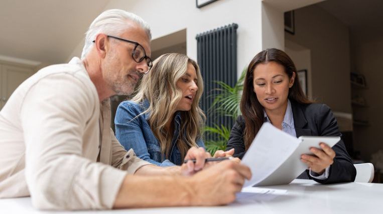 A couple meets with their financial advisor to discuss using a deferred sales trust to delay paying capital gains taxes on the sale of a property.