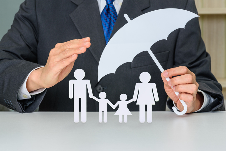 Cardboard cutout of a family protected by a cardboard cutout of an umbrella.