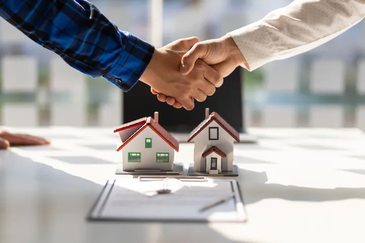 Real estate agents shake hands after the signing of the contract.